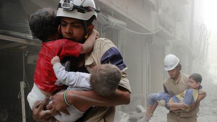 Nach einem Luftangriff: Syrische Weißhelme bergen im Jahr 2014 Kinder aus den Trümmern.