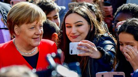 Auf gleicher Selfiehöhe: Was für die Kanzlerin - hier beim EU-Projekttag an einer Berliner Schule am Dienstag - selbstverständlich ist, sieht am Arbeitsplatz für Menschen mit Migrationsgeschichte oft ganz anders aus. 