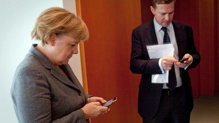 Bundeskanzlerin Angela Merkel und ihr Sprecher Steffen Seibert beim kommunizieren.