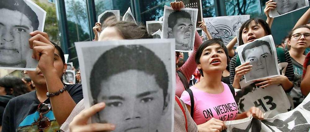 Demonstranten halten Fotos der verschwundenen Studenten in die Höhe.