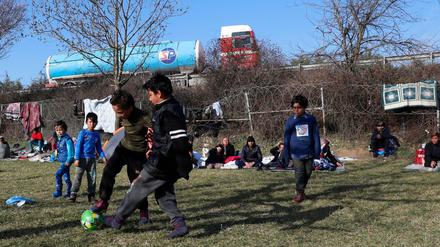 Flüchtlingskinder spielen auf türkischer Seite vor dem Grenzzaun zu Griechenland Fußball. 