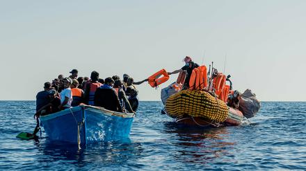 Hilfskräfte nähern sich einem Boot mit Migranten auf dem Mittelmeer.
