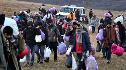 Migranten gehen mit ihren Habseligkeiten zurück zum Lager Lipa in Bosnien-Herzegowina.