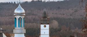Integration: Das Minarett und die Kuppel einer Moschee neben einem Kirchturm in Usingen im Taunus