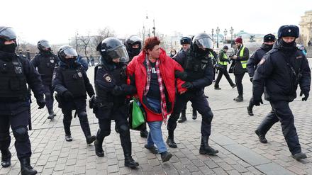 Polizisten nehmen eine Demonstrantin in Moskau fest.