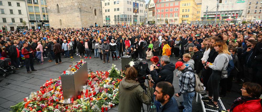 Auf dem Marktplatz in Halle legen Menschen als Zeichen der Trauer Blumen ab.