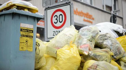 Mülltonnen und gelbe Säcke mit Kunststoff-Abfällen