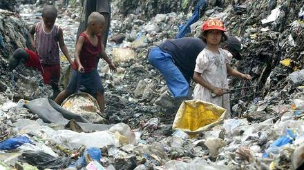 Philippinische Kinder durchsuchen eine Müllhalde nach brauchbaren Materialien.