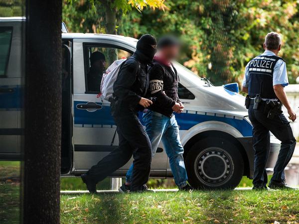 Die mutmaßliche Rechtsterroristen, die am Montag in Bayern und Sachsen festgenommen wurden, erreichen den Bundesgerichtshof und werden von Polizisten abgeführt. 