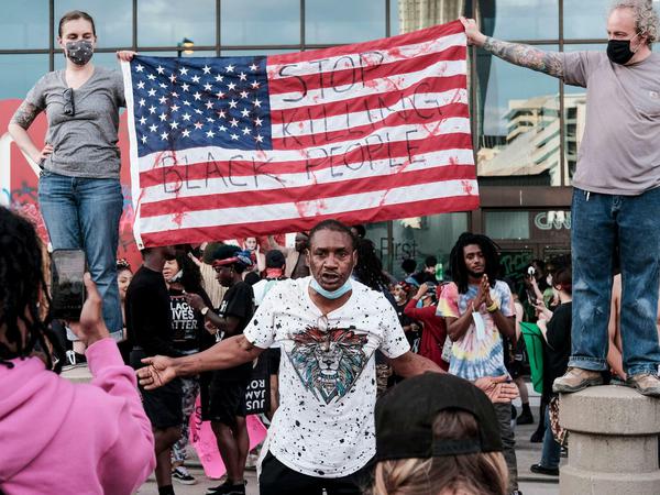 Demonstranten vor dem Gebäude des Senders CNN mit einer US-Flagge auf die der Satz "Stop killing black people" (Hört auf, schwarze Menschen zu töten) geschrieben wurde.