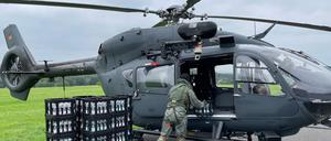 Ein Soldat entlädt am Nürburgring Kisten mit Trinkwasser aus einem Hubschrauber der Spezialkräfte vom Typ H145M. 