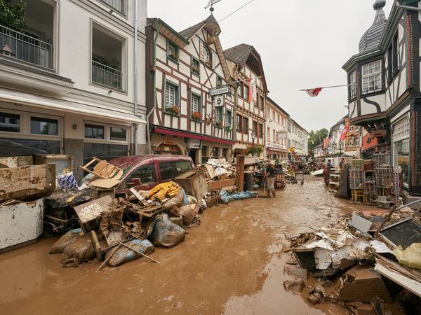 Anwohner und Ladeninhaber in Bad-Neuenahr-Ahrweiler versuchen, ihre Häuser vom Schlamm zu befreien.