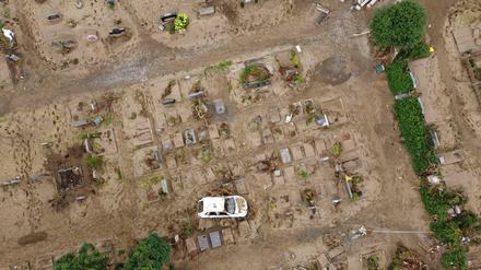 Ein Auto, das bei der Hochwasserkatastrophe auf den Friedhof geschwemmt worden ist, steht auf einem Grabfeld (Luftaufnahme mit einer Drohne).