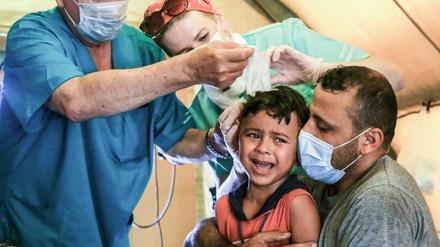 Russische Sanitäter untersuchen die Wunden von Hussein, einem sechsjährigen syrischen Jungen.