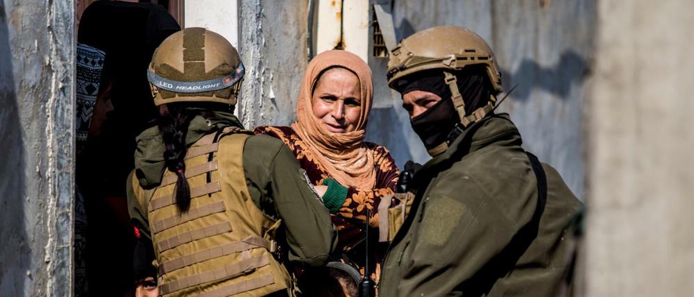 Soldaten der Demokratischen Kräfte Syriens suchen nach IS-Anhängern und befragen eine Anwohnerin.