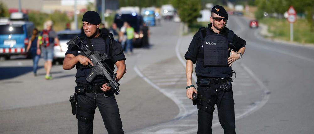 Zwei bewaffnete Polizisten bewachen am Montag eine Straße in der Nähe von Subirats (Spanien), wo ein verdächtiger Terrorist getötet wurde. 