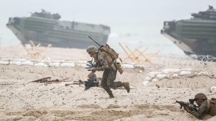 US-amerikanische Nato-Soldaten laufen am 16.06.2016 in Ustka in Polen bei einem Marinemanöver über einen Strandabschnitt vor Amphibienpanzern. An der Übung nahmen 17 Länder mit 6100 Soldaten teil. 