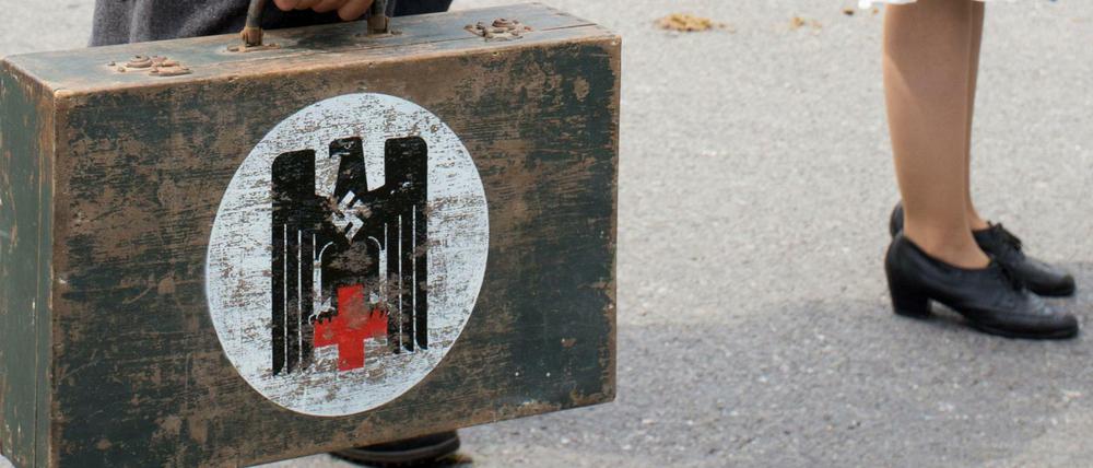Der DRK-Adler auf dem Koffer eines Mannes, der am Sonntag in Colmnitz (Sachsen) bei einem historischen Festumzug zum "Schul- und Heimatfest" als Wehrmachtssoldat verkleidet mitläuft. Die Polizei ermittelt wegen des Verwendens von Kennzeichen verfassungswidriger Organisationen.