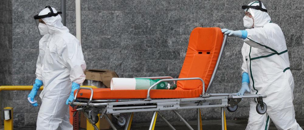 Krankenhausmitarbeiter holen mit einer Bahre einen covid-kranken Menschen in Neapel für den Transport ins Krankenhaus ab. 
