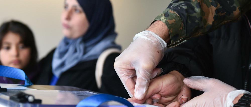 Dem Vater einer Flüchtlingsfamilie aus dem syrischen Aleppo werden im Registrierungszentrum einer Flüchtlingsunterkunft in Heidelberg Fingerabdrücke abgenommen. Mit Hilfe des Registrierungszentrums sollen Asylanträge schneller abgewickelt werden.