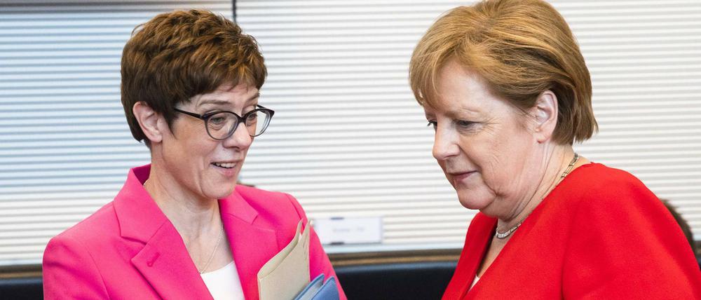 Bundeskanzlerin Angela Merkel (r.) und die CDU-Vorsitzende Annegret Kramp-Karrenbauer sprechen vor einer Sitzung der CDU/CSU Bundestagsfraktion in Berlin.