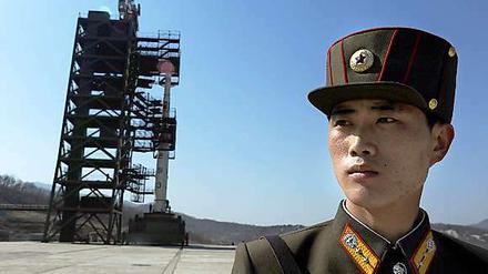 Ein Nordkoreanischer Soldat bewacht die Unha-3 Rakete in Tangachai. Ungeachtet der internationalen Kritik hat Nordkorea mit der Betankung der umstrittenen Rakete begonnen.