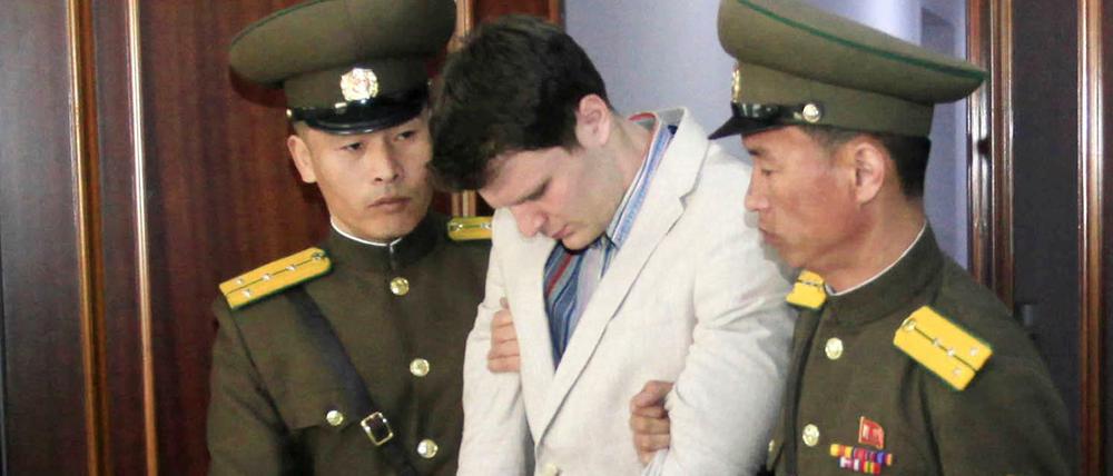 Der US-Bürger Otto Warmbier (M) wird am 16.03.2016 in einem Gericht in Pjöngjang (Nordkorea) von zwei nordkoreanischen Polizisten eskortiert. 