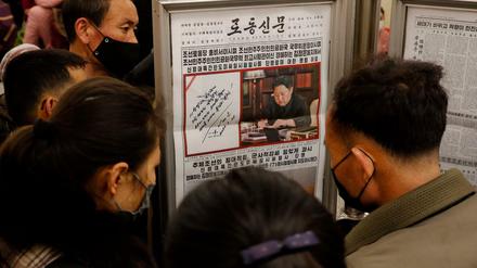 Nordkoreaner lesen in Pjöngjang Berichte über einen Raketentest ihres Landes (Aufnahme vom 25. März 2022).