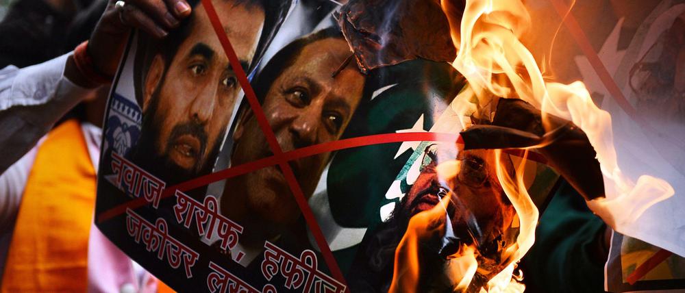 Demonstranten verbrennen in Neu-Delhi Poster mit den Gesichtern von Nawaz Sharif, Hafiz Muhammad Saeed und Zaki-ur-Rehman Lakhvi, die sie für die Hintermänner der Anschläge von Mumbai halten.