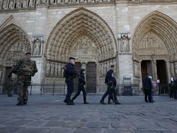 Sicherheitskräfte patrouillieren am Sonntag vor Notre Dame in Paris.