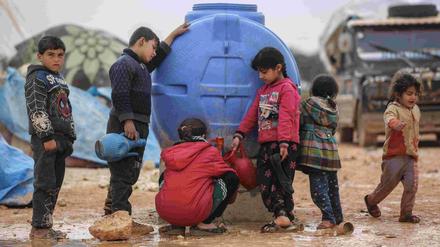 Kinder in einer Notunterkunft in Idlib holen Trinkwasser.