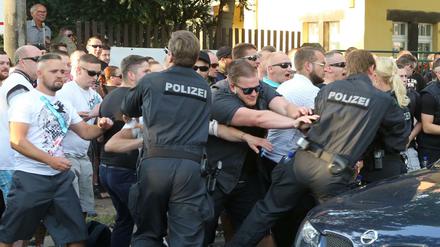 Teilnehmer der NPD-Demonstration in Dresden rangeln mit Polizeibeamten.