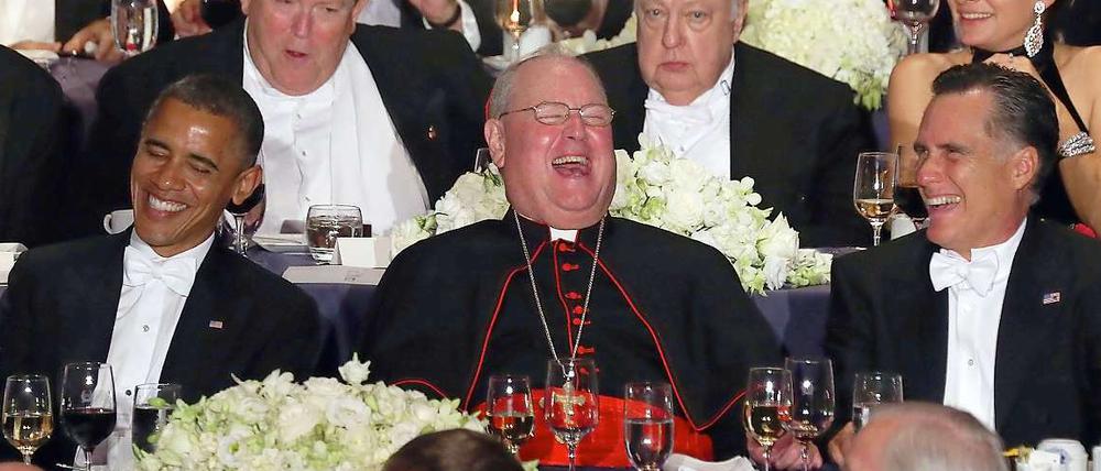 Wer ist der Witzigste im ganzen Land? Kardinal Timothy Dolan zwischen den Stühlen.