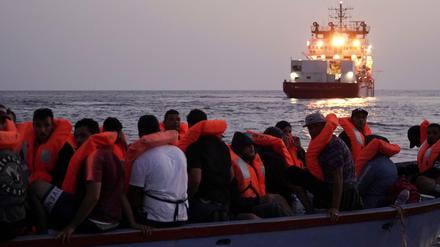 Migranten auf einem überfüllten Holzboot warten auf die Rettung durch die Ocean Viking.
