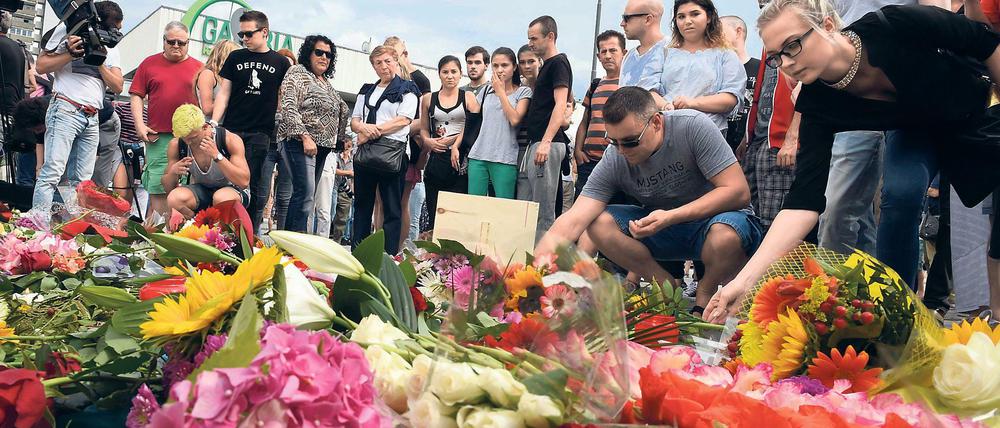 "Auch die Kommune mitten ins Herz getroffen" - Trauernde vor dem Olympia-Einkaufszentrum nach den Morden.