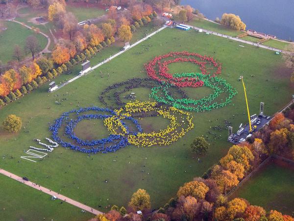 Mehrere Tausend Menschen bildeten Anfang November mit verschiedenfarbigen Ponchos im Hamburger Stadtpark die Olympischen Ringe. Die Gegner steuerten (links) ein kleines "NO" bei.