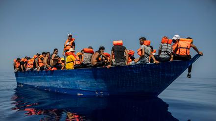 Eine Gruppe mutmaßlicher Migranten aus Tunesien sitzen an Bord eines Holzbootes – etwa 32 Kilometer südwestlich der italienischen Insel Lampedusa (Archivbild).
