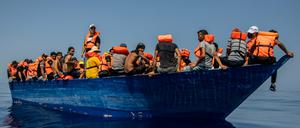 Eine Gruppe mutmaßlicher Migranten aus Tunesien sitzen an Bord eines Holzbootes – etwa 32 Kilometer südwestlich der italienischen Insel Lampedusa (Archivbild).