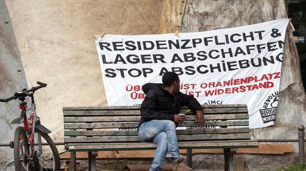 Afrikaner betrachtet ein Plakat gegen Abschiebung auf dem Oranienplatz in Berlin