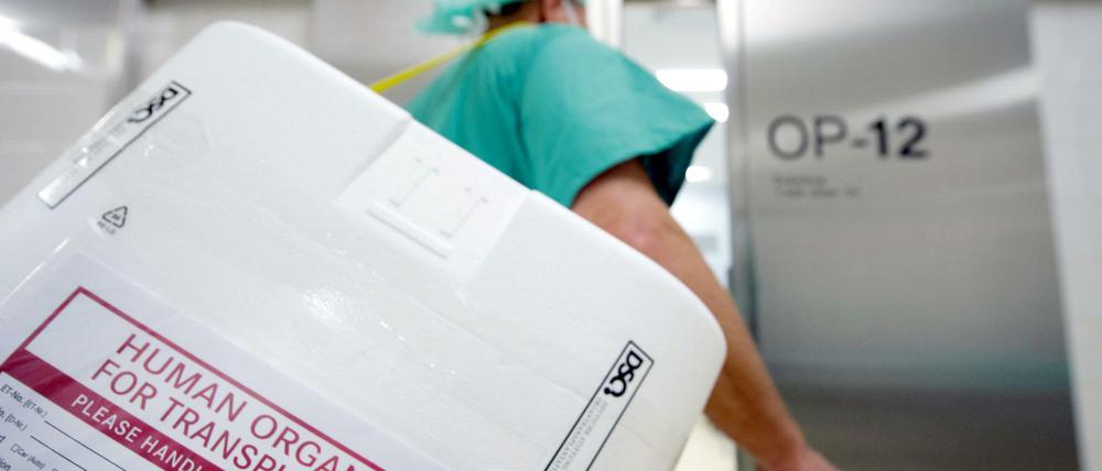 Ein Styropor-Behälter zum Transport von zur Transplantation vorgesehenen Organen wird am Eingang eines OP-Saales vorbei getragen.