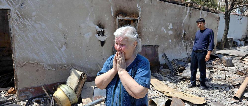 Verfolgt. Eine Usbekin steht in der Stadt Osch vor den Trümmern ihres niedergebrannten Hauses.