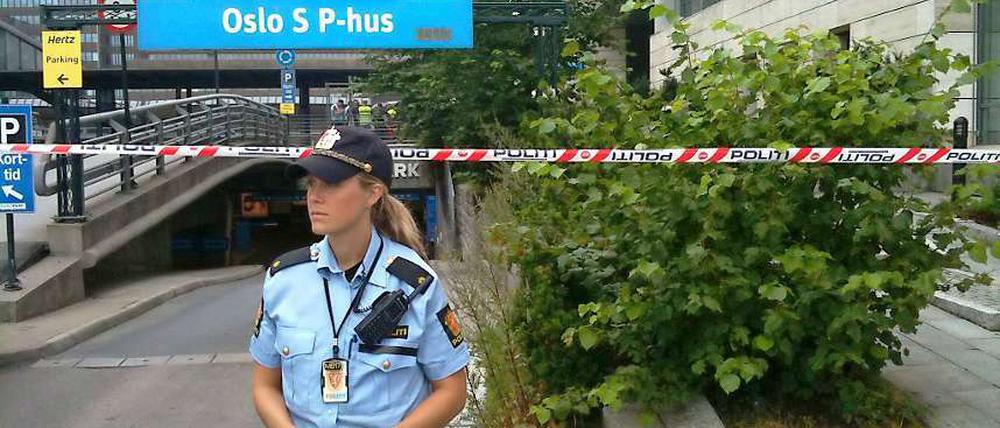 Eine Polizistin wacht vor einer Absperrung am Osloer Hauptbahnhof.