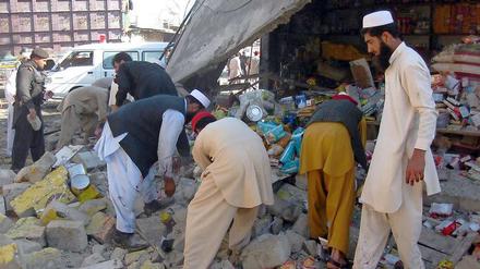 Pakistanische Sicherheitskräfte und Anwohner suchen nach dem Bombenanschlag nach Opfern.