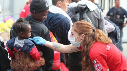 Palermo, Ende Juni: Eine Mitarbeiterin des italienischen Roten Kreuzes nimmt Migranten in Empfang.