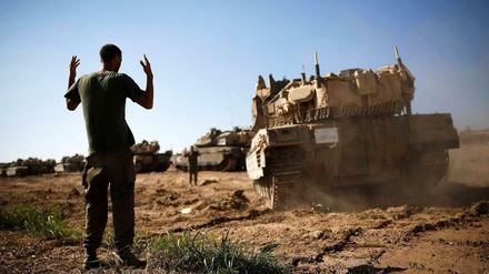 Israelischer Soldat weist Panzer im Grenzgebiet zu Gaza ein.