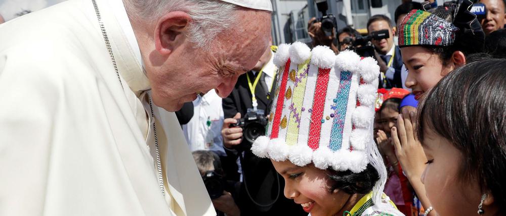 Papst Franziskus wird bei seiner Ankunft am Yangon International Airport in Myanmar von Kindern in traditioneller Kleidung begrüßt.