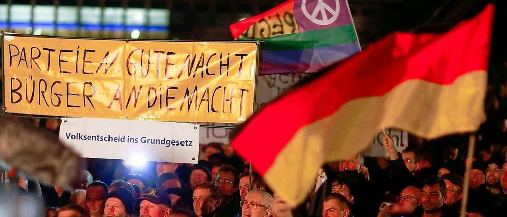 Diffuser Protest. "Pegida"-Demonstranten am Montag in Dresden. Im Hintergrund eine Friedensfahne.