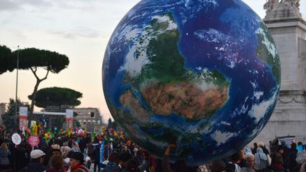 Weltweit haben am Wochenende hunderttausende Menschen für ein besseres Klima demonstriert. Das Foto zeigt Demonstranten in Rom, die eine Weltkugel dabei haben. 