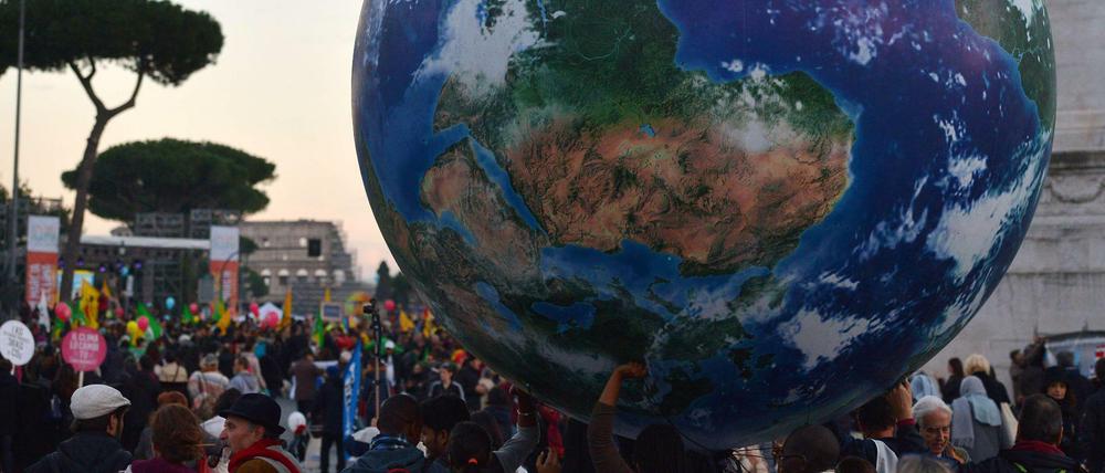 Weltweit haben am Wochenende hunderttausende Menschen für ein besseres Klima demonstriert. Das Foto zeigt Demonstranten in Rom, die eine Weltkugel dabei haben. 