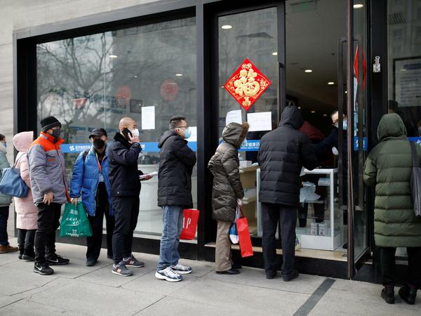 Menschen stehen in Peking in einer Schlange an, um Atemmasken zu kaufen.